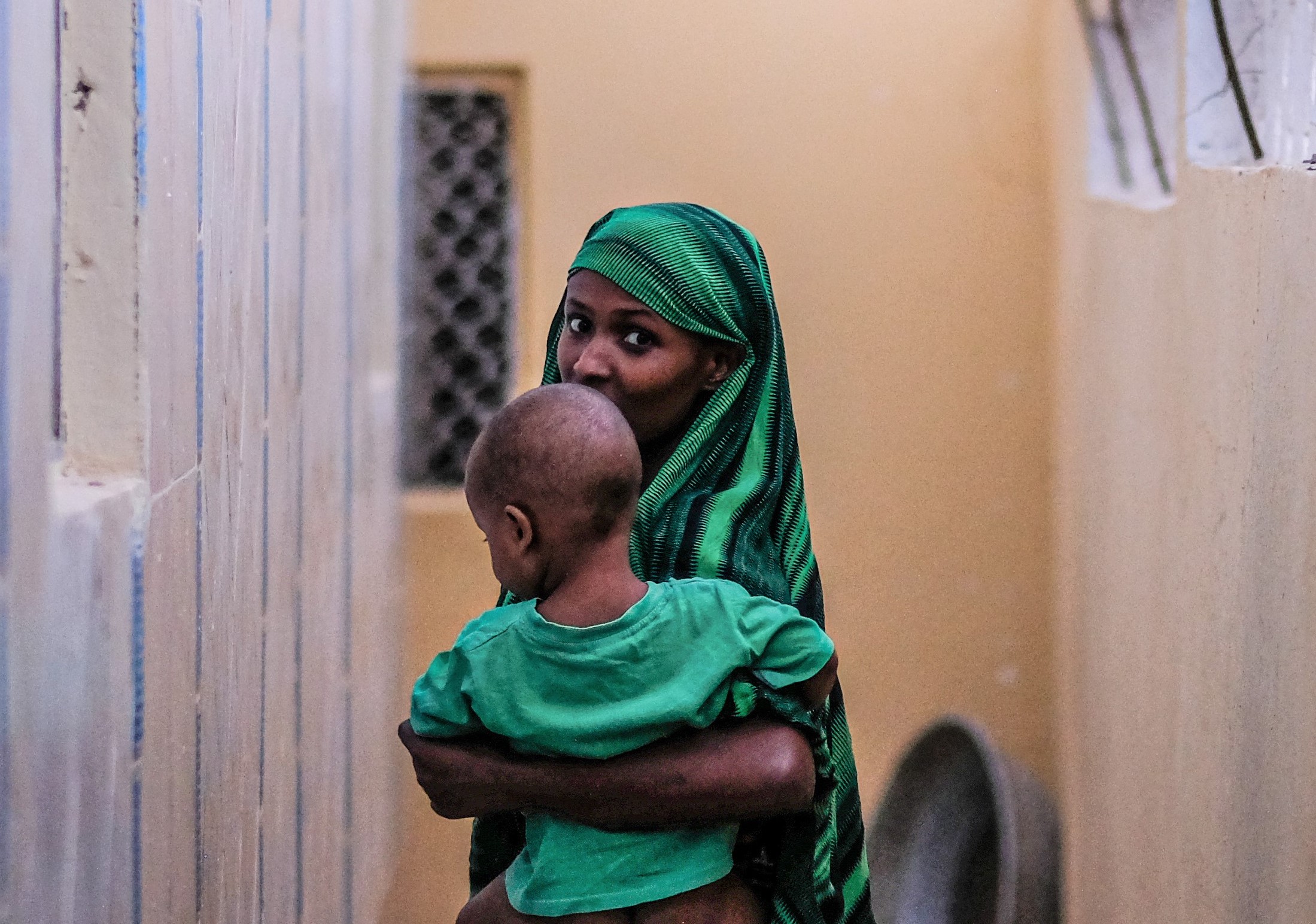 Kvinde med sit barn i armene