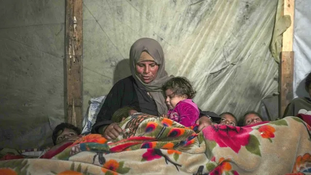 Mor og barn varmer sig under tæppe